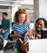 coworkers smiling while discussing a project
